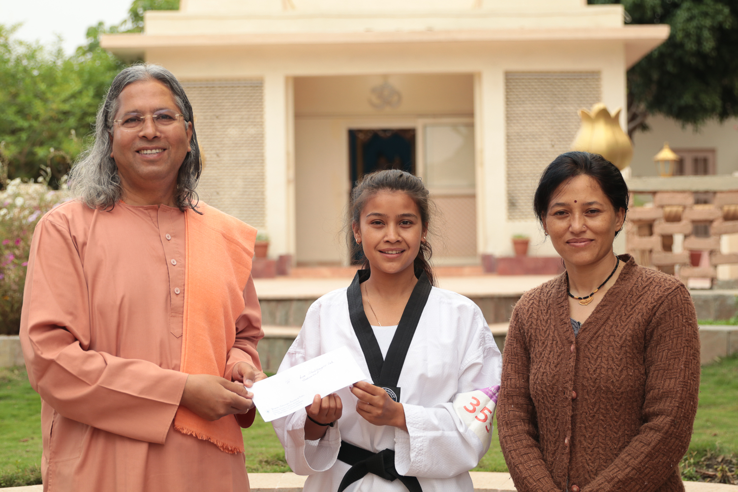 Swami Vasudevananda presents scholarship to Kum. Alisha, a third year engineering student